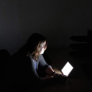A person browsing the Internet in the dark.
